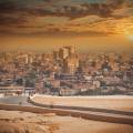 The city of Cairo at the end of a dusty path in front of the setting sun