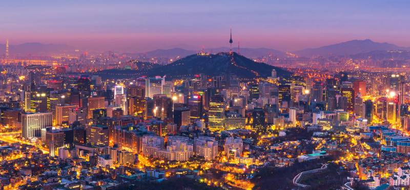 The skyline of Seoul in South Korea at dusk with the city lights gleaming